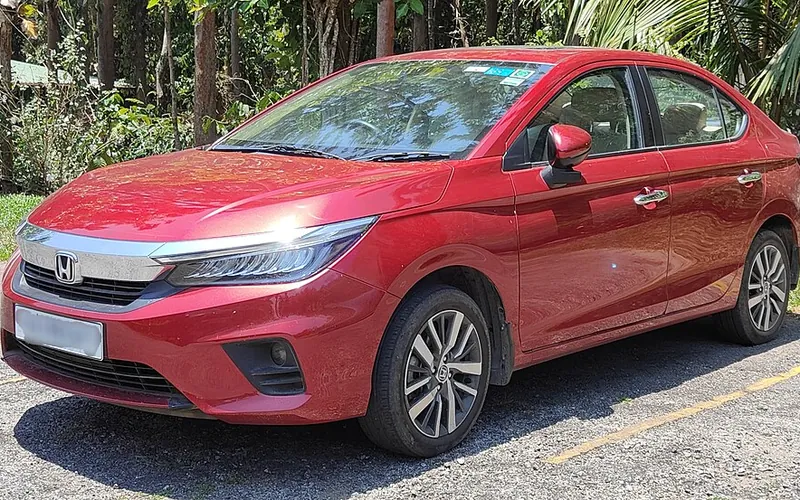 Red Honda City premium sedan taxi, front three-quarter view
