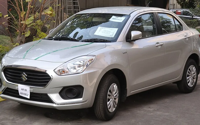 Silver Maruti Suzuki Swift Dzire sedan taxi, front three-quarter view